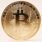 A golden Bitcoin coin standing upright against a minimalist light background.